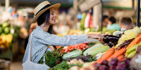 Woman shopping for fresh vegetables at a market.