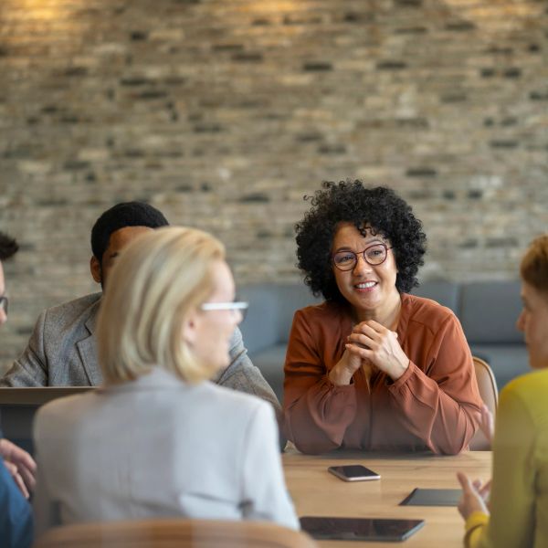 Diverse group in a lively office meeting, engaged in discussion.