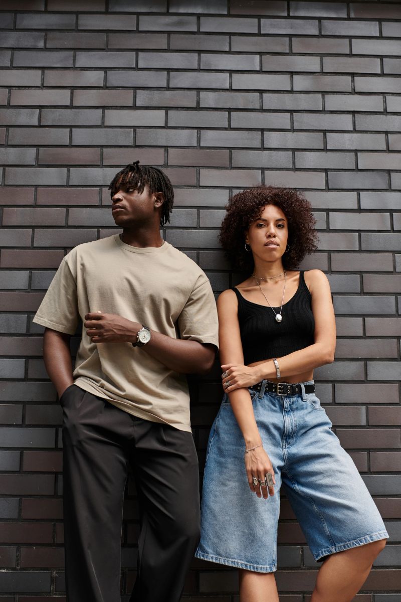 Stylishly dressed young couple share a relaxed moment together in a vibrant city.