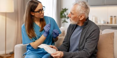 Nurse explaining a swab test to an elderly man.