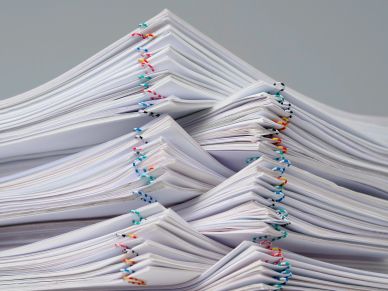 Large stacks of paper clipped with colorful clips.