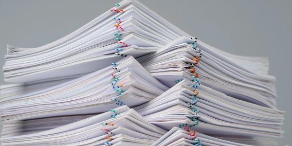 Stacks of paper clipped together with colorful paperclips.