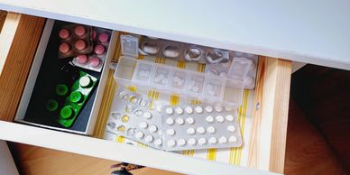 Open drawer with organized medications and pills.
