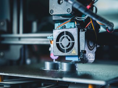 Close-up of a 3D printer nozzle working on a print.
