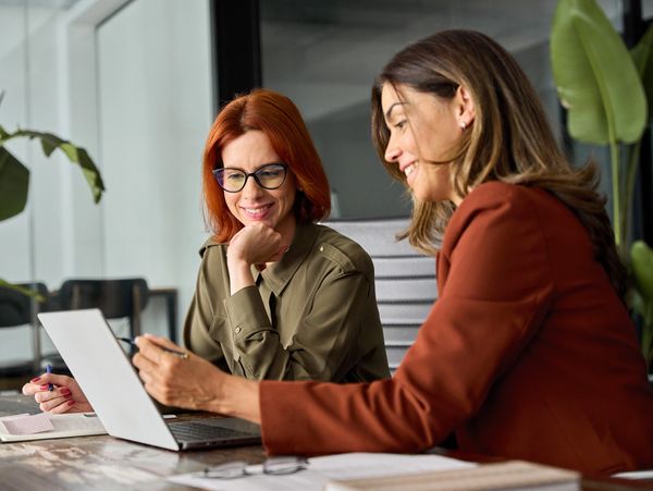 Two women using a laptop.