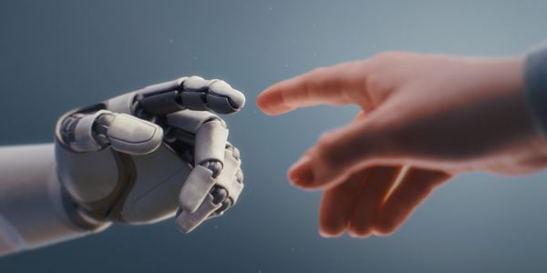 A robotic hand and a human hand reaching towards each other.