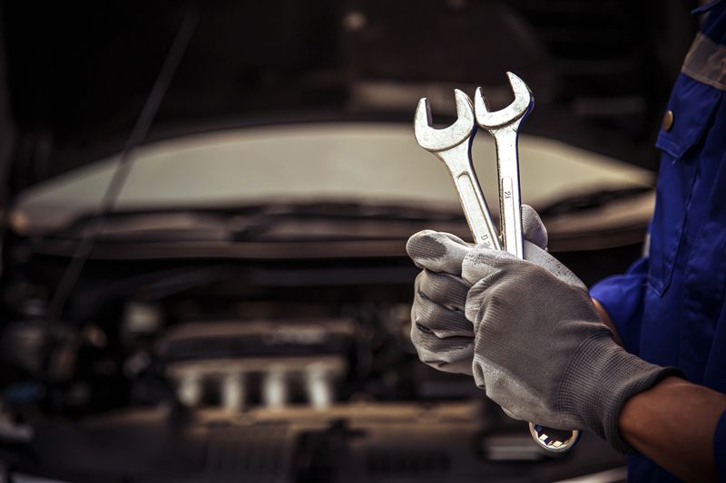 Car care maintenance and servicing, Close-up hand technician auto mechanic using the wrench to repairing change spare part car engine problem and car insurance service support.