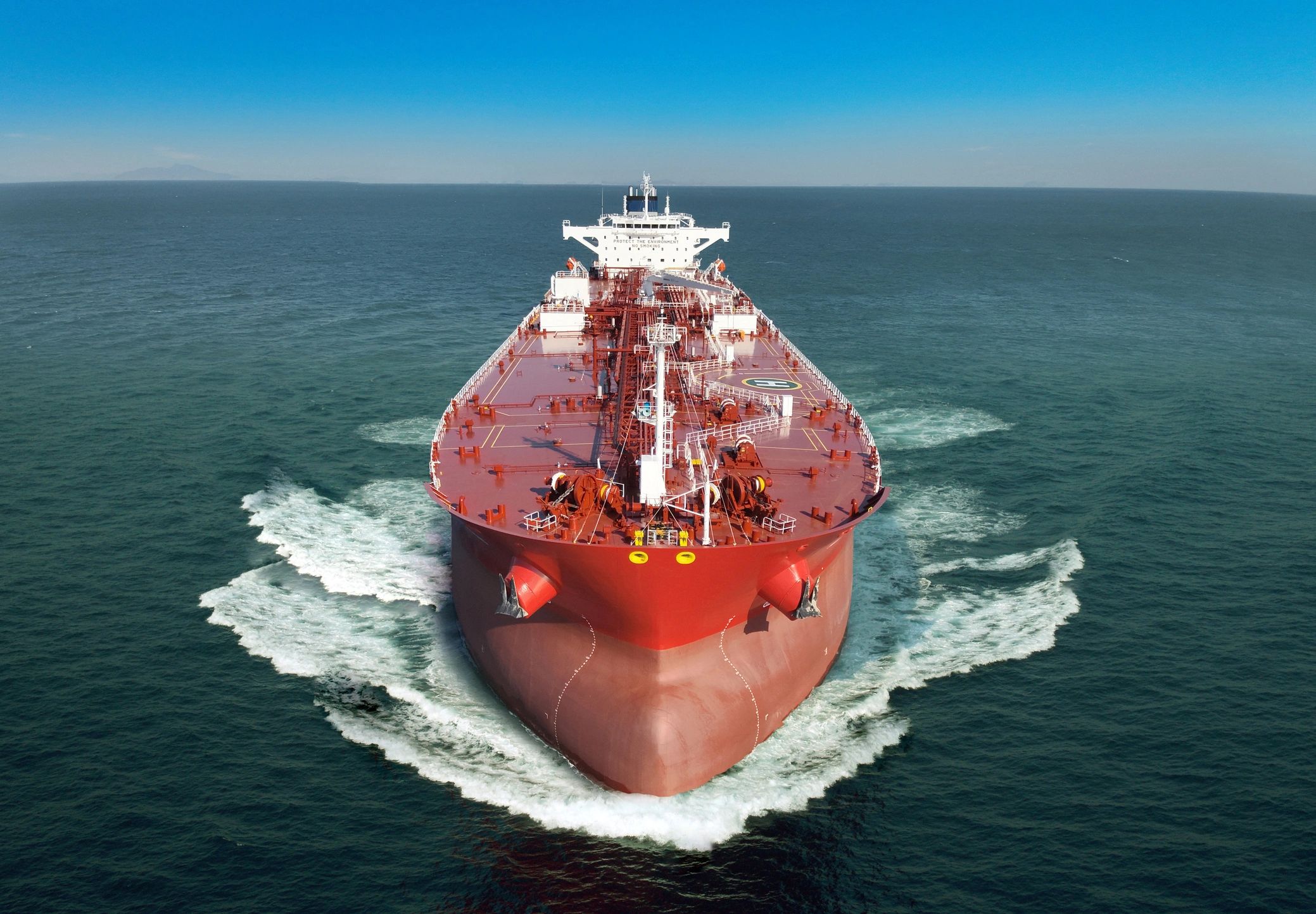 Large red cargo ship cruising in the ocean.