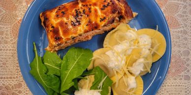 Plate with meat pie, ravioli, and greens.
