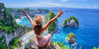 Woman enjoying a scenic ocean view from a cliff.