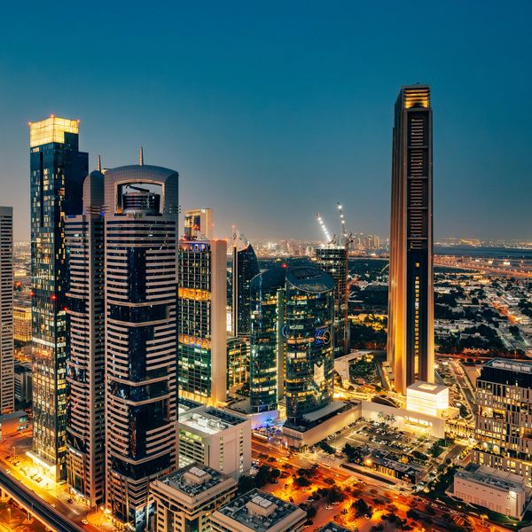 Nighttime cityscape with illuminated skyscrapers and streets.