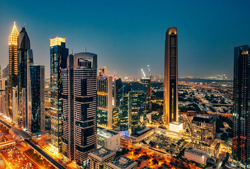 Admire the illuminated skyscrapers of Dubai's skyline along Sheikh Zayed Road under the twilight sky.