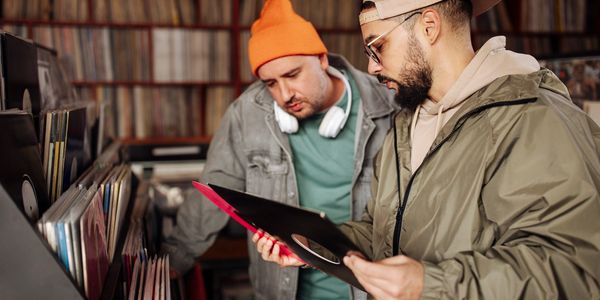 Two men browsing vinyl records in a music store.