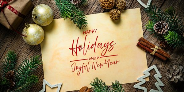 a holiday scene with pine with a note that says happy holidays and a joyful new year