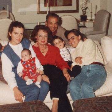 Family gathering with three generations on a couch.