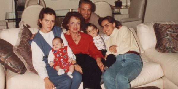 Family gathering on a couch with multiple generations.