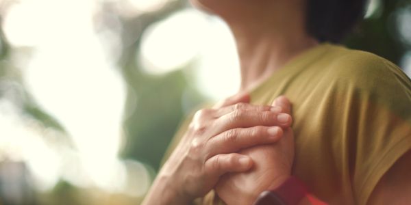 Person holding their chest, expressing emotion.