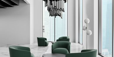 Modern lounge with green chairs and a striking metallic chandelier in a bright, high-ceiling space.