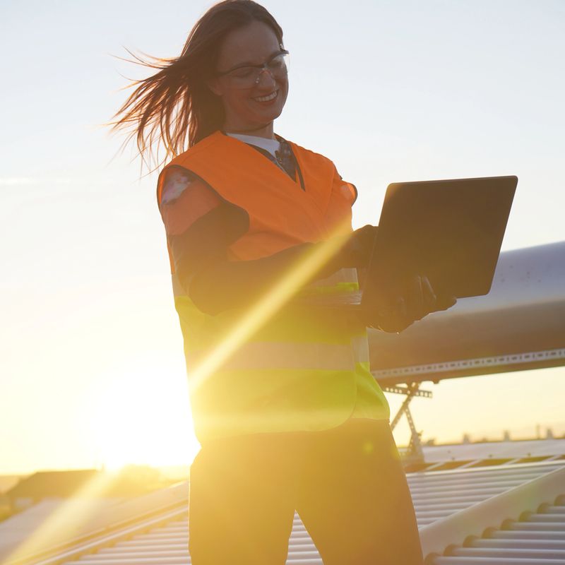 renewable energies. technical woman of installation of solar panels with laptop next to the solar vacuum tube panels.