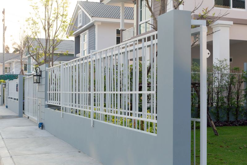 House fence composed of concrete wall and metal steel, modern contemporary architecture design. Offering decoration, security, protection and privacy. Ideal for residential building exterior visuals.
