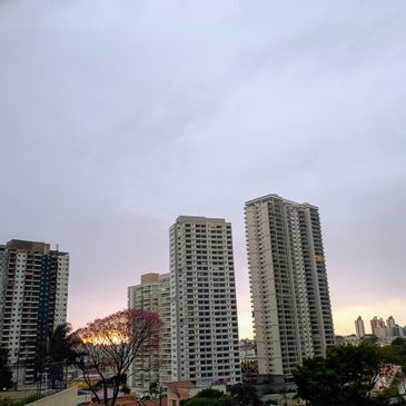 Tall residential buildings under a cloudy sky at sunset.