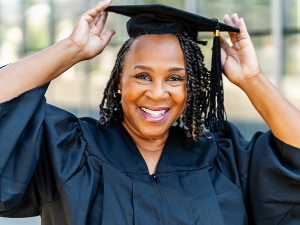 Happy graduate adjusting cap.