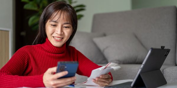 Elderly couple sitting on a couch using a tablet together.