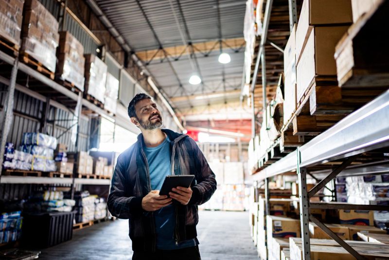 Mature businessman working on a digital tablet in a warehouse