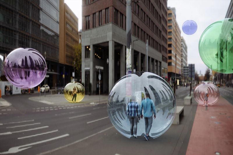 People inside glass bubble spheres in urban street with flying spheres around. (3d render)