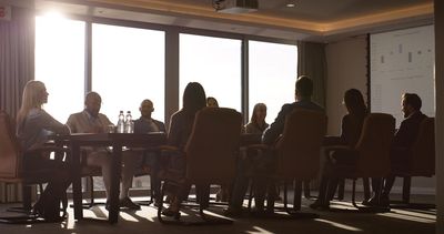 Group meeting in a conference room with large windows.
