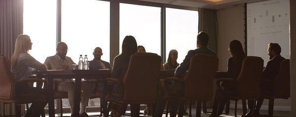 A diverse group of people having a meeting in a cozy room with brick walls.