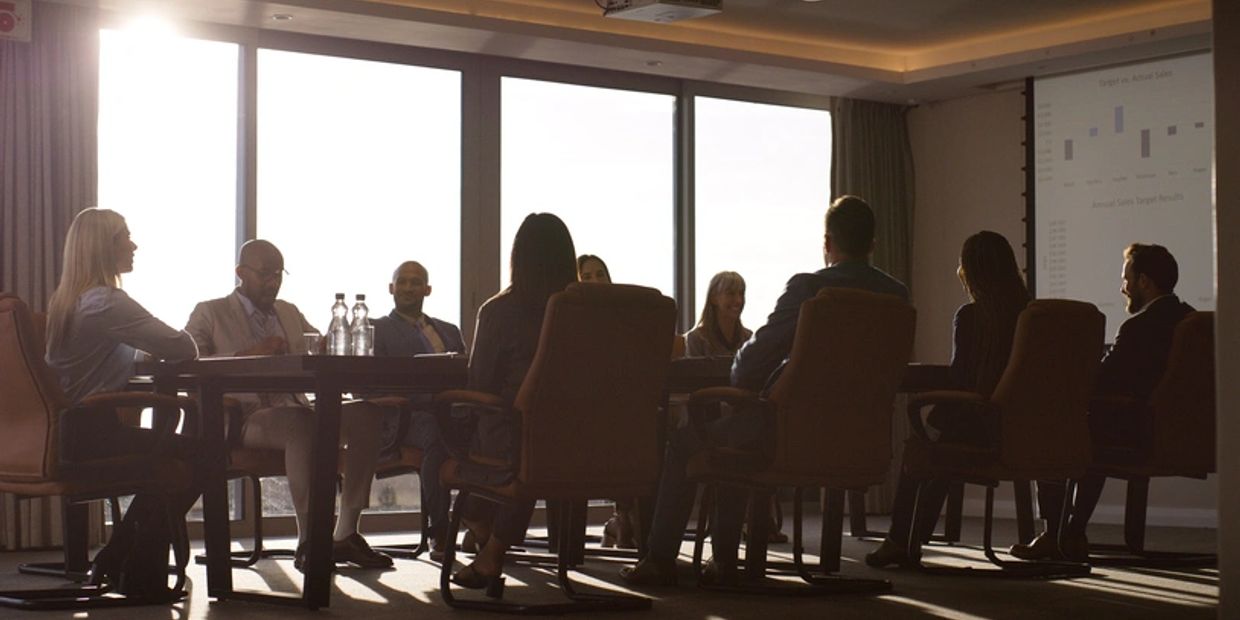 Business team in a meeting with a presentation in a bright conference room.