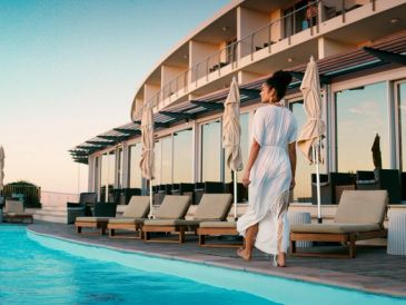 Mujer caminando junto a una piscina en un hotel.