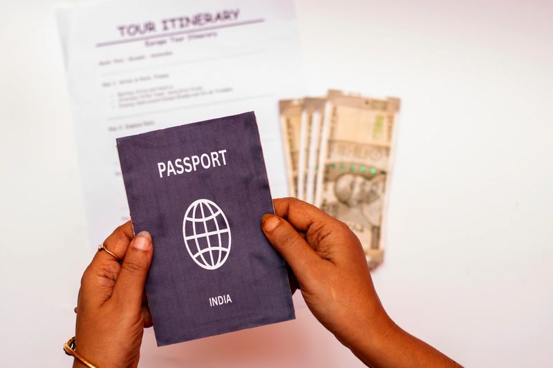 Close-up of an Indian woman holding a passport, Indian currency, and a Europe travel itinerary, symbolizing international trip planning, tourism, and vacation budgeting.