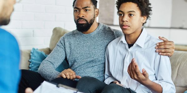 Father comforting son during a counseling session.