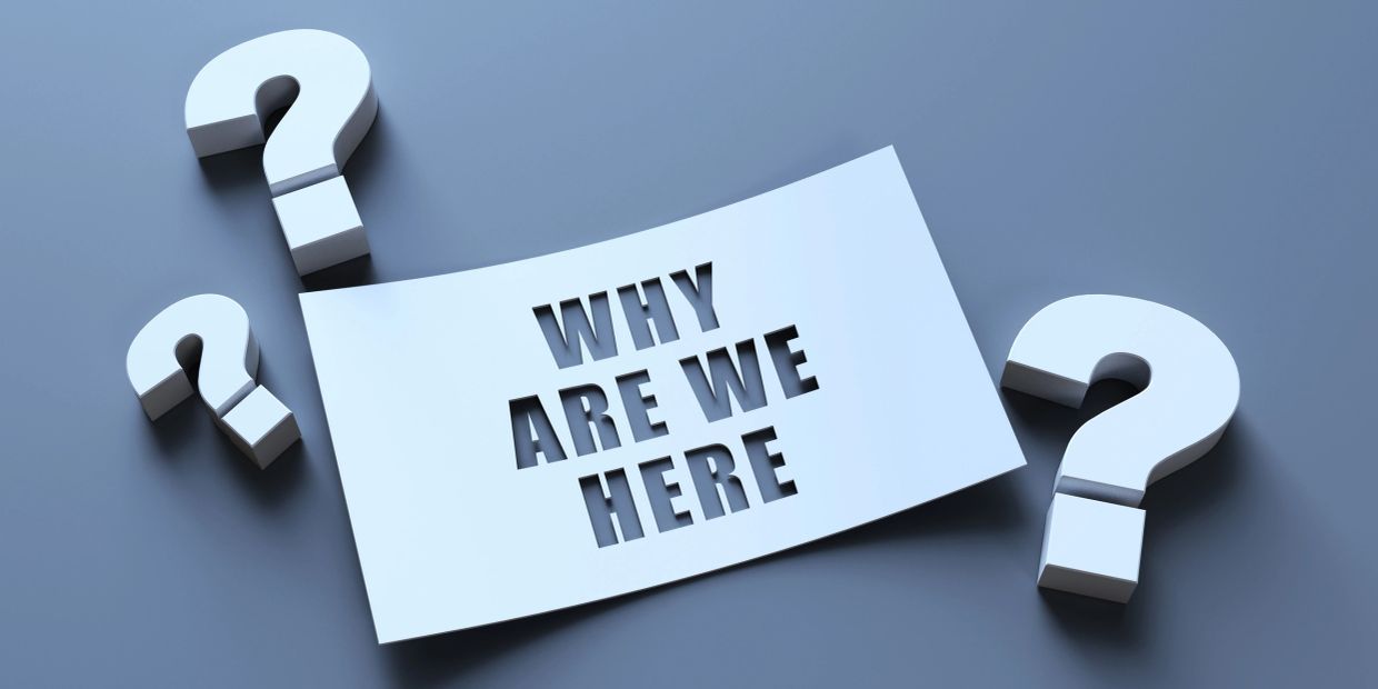 A paper with 'WHY ARE WE HERE' cut out surrounded by question marks.
