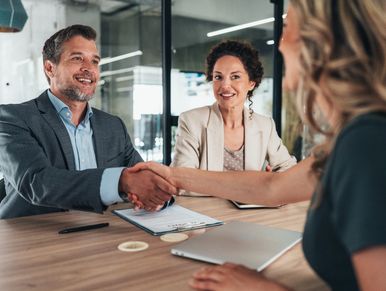 Business professionals shaking hands during a meeting in an office.