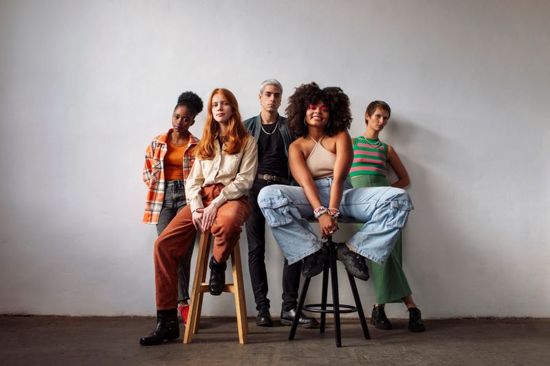 A fashionable group of multicultural Gen Z individuals poses confidently in a studio setting; Casual clothing, vibrant personalities, and modern vibes highlight their diversity and creativity