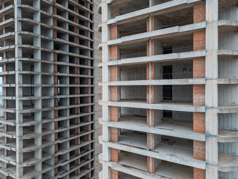 Unfinished High-Rise Building Showcasing the Raw Structure of Construction, Incomplete Skyscraper Revealing the Ongoing Process of Urban Development. High quality photo