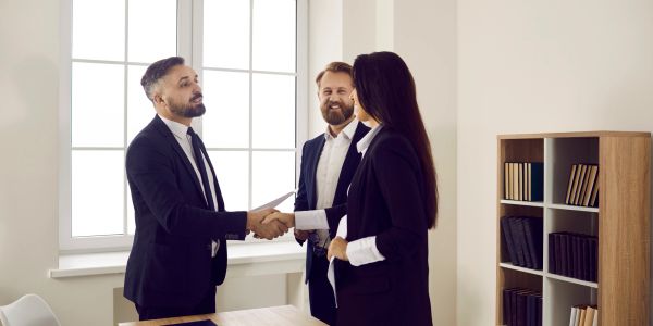 Business professionals shaking hands in office.