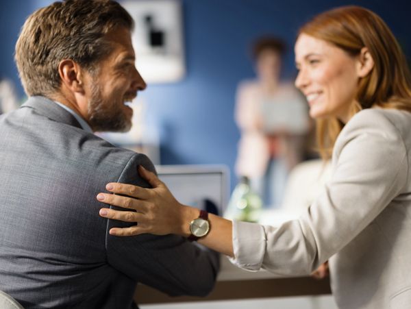Colleagues sharing a warm and encouraging moment at work.
