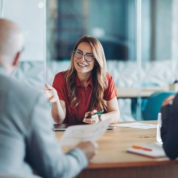 Woman smiling and talking in a meeting.