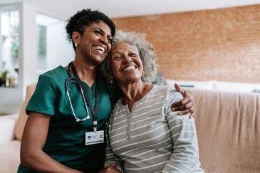 Nurse and elderly woman sharing a joyful moment.
