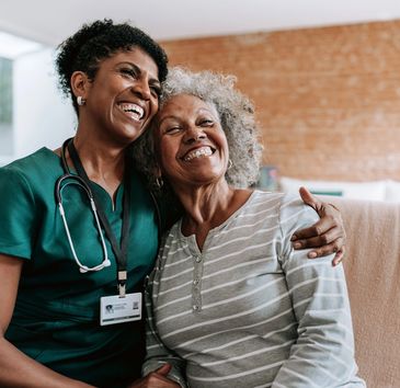 Nurse and elderly woman sharing a joyful moment.
