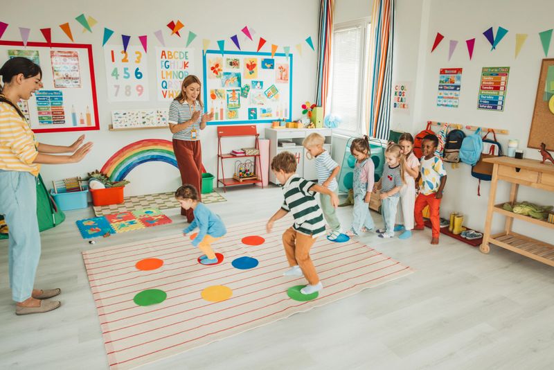 Group of kids in class with teacher repeating after her rising hands making active exercise.