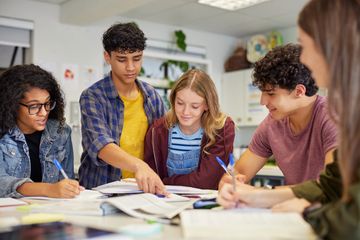 A group of diverse students collaborating on a project in a classroom.
