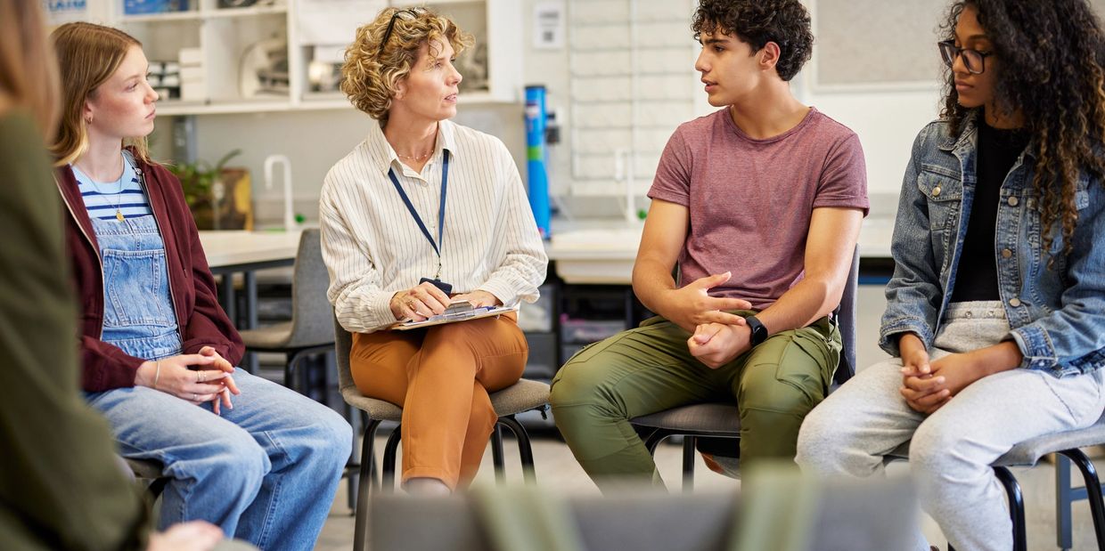 A group discussion with attentive participants seated in a circle.