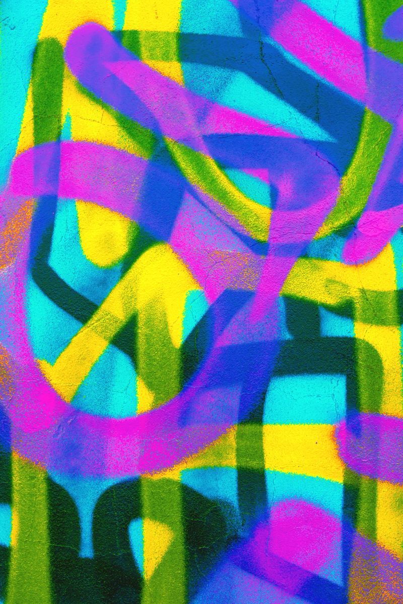 Bold graffiti pattern in neon blue, purple, yellow. 80s, Y2K style, fluorescent, urban art vibe. Modern street art, creative backgrounds, digital projects, urban-themed visuals.