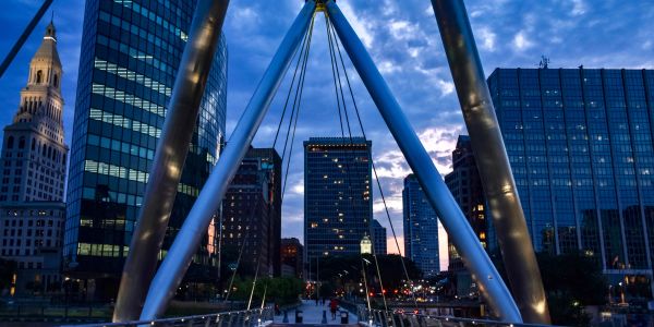 City skyline viewed from a modern bridge at dusk.