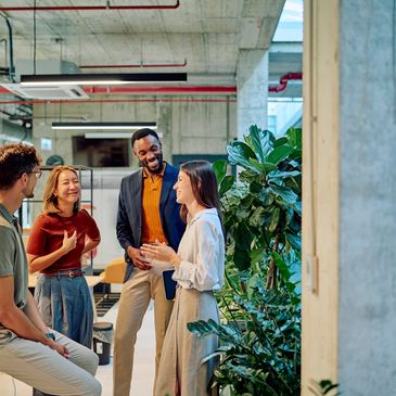 A group of coworkers chatting in a modern office.